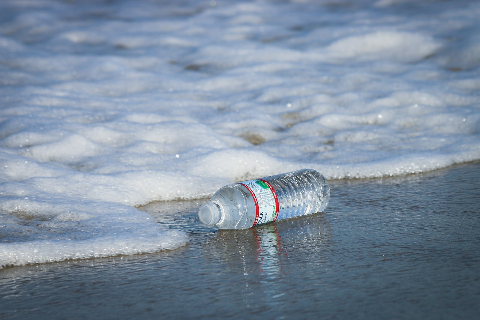 Bottiglia di plastica abbandonata vicino all'acqua